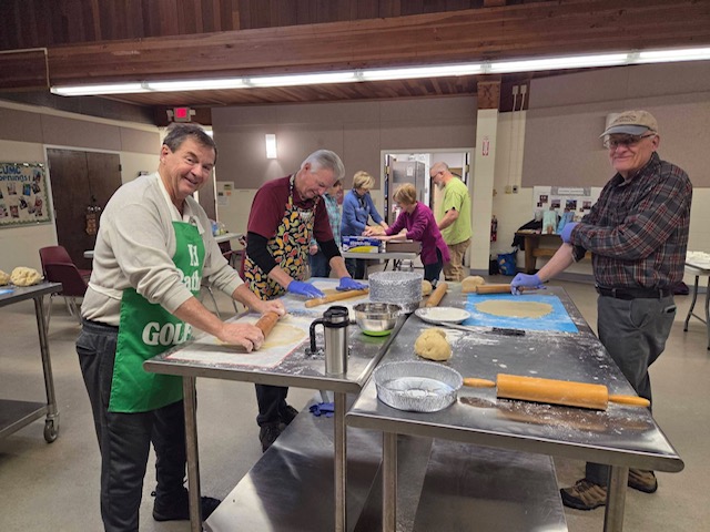 Volunteers rolling pie dough for the apple pie fundraiser