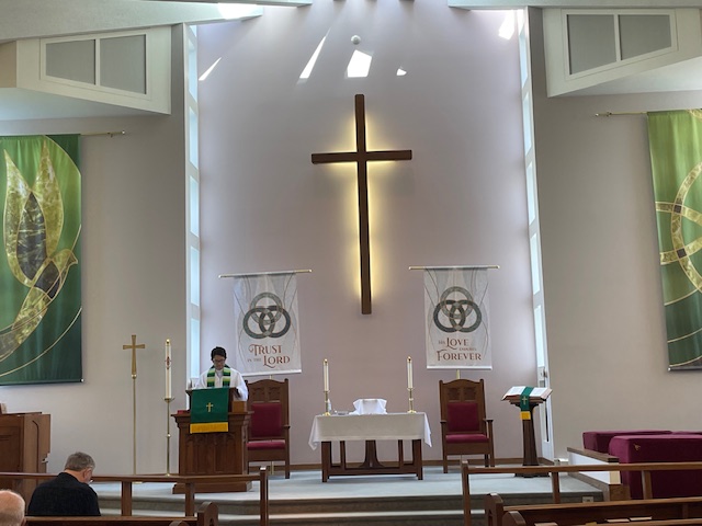 Cheshire United Methodist Church sanctuary with wooden cross and green banners